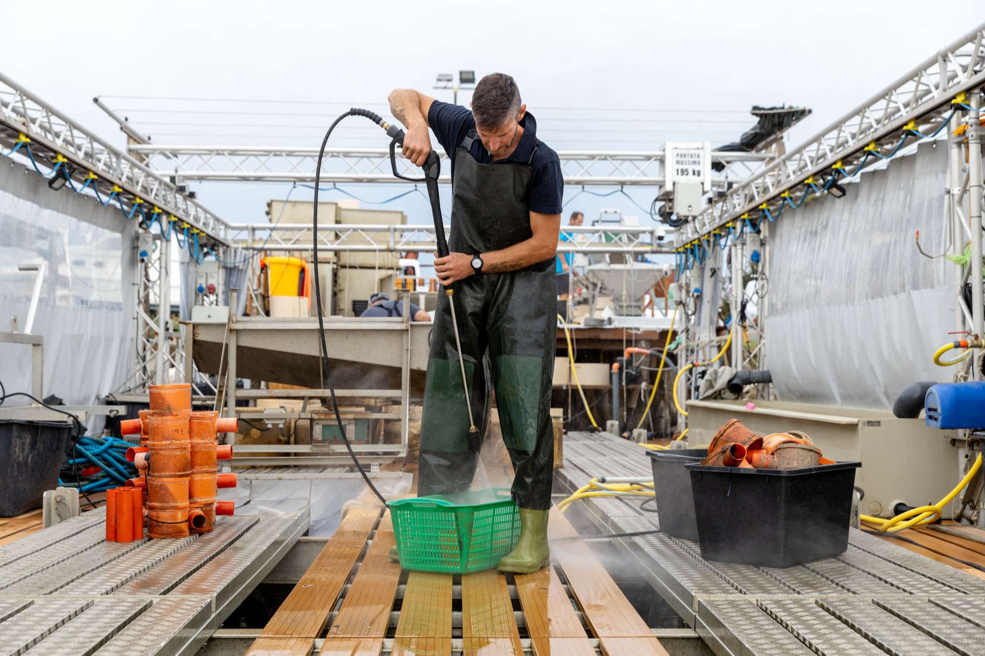 Pescatore di Coop Gorino pulisce impianto di allevamento vongole.
